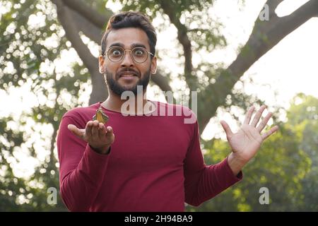 Un homme portant des lunettes et la lampe d'Aladin dans sa main Banque D'Images