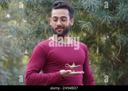 Un homme portant des lunettes et la lampe d'Aladin dans sa main Banque D'Images