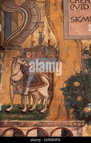 Une troupe de cavalerie - apparemment des femmes - se cachent derrière un arbre d'un autre groupe de cavaliers, peut-être pour les embuer, dans l'art peint du XVIIe ou XVIIIe siècle sur la façade peinte colorée de Haus Claglüna, une maison familiale traditionnelle historique à Ardez, Grisons ou Grisons canton de l'est de la Suisse.La propriété est plus connue sous le nom de "la maison Adam et Eve" de sa représentation, datant de 1647, du jardin d'Eden. Banque D'Images