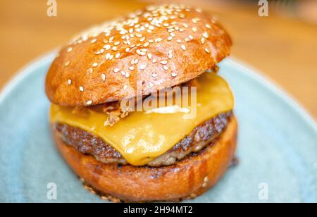 Hamburger de bœuf artisanal avec cheddar.Délicieux cheeseburger avec oignon croustillant sur une assiette. Banque D'Images