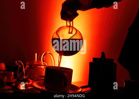 Cérémonie traditionnelle du thé asiatique.Le thé chaud dans une théière verse le thé à la vapeur dans une tasse Banque D'Images