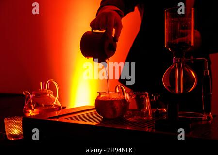 Cérémonie traditionnelle du thé asiatique.Le thé chaud dans une théière verse le thé à la vapeur dans une tasse Banque D'Images