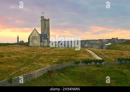 Coucher de soleil sur l'église St Helen, Old Light et Lundy village sur Lundy Island, Bristol Channel, Devon, Angleterre, Royaume-Uni Banque D'Images