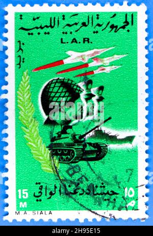 Photo d'un timbre-poste vert de la République arabe libyenne comportant des graphiques militaires pour célébrer la révolution en 1969 Banque D'Images