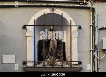 Gros plan d'un sanctuaire votif sur la façade d'un ancien bâtiment dans la rue via San Vincenzo, Gênes, Ligurie, Italie Banque D'Images
