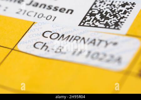 Stuttgart, Allemagne - 04 décembre 2021 : vaccination de rappel contre le virus Corona Covid-19.Carte de vaccination jaune avec étiquette d'épreuve.Vaccin de Bi Banque D'Images