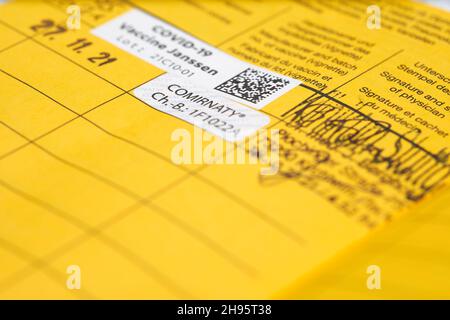 Stuttgart, Allemagne - 04 décembre 2021 : vaccination de rappel contre le virus Corona Covid-19.Carte de vaccination jaune avec étiquette d'épreuve.Vaccin de Bi Banque D'Images