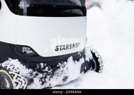 Tallinn, Estonie - 4 décembre 2021 : un drone autonome de Starship technologies conduit dans la neige en hiver.Robot de livraison auto-pilotant. Banque D'Images