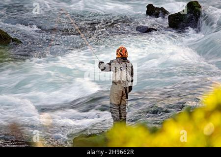 Un homme pêche à la mouche le long d'une section de Dillon Falls sur la rivière Deschutes, dans le centre de l'Oregon, près de la ville de Bend. Banque D'Images