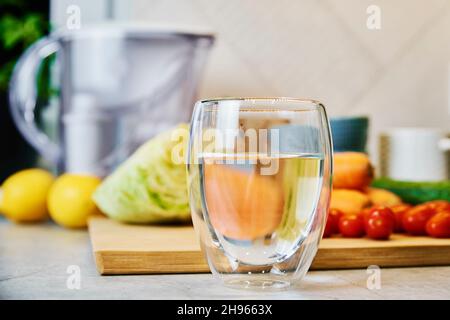 Verre d'eau pure, cartouche filtrante de nettoyage et légumes frais sur la table Banque D'Images