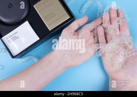 Femme tenant des aligneurs transparents invisibles invisalign ou des appareils orthodontiques en plastique. Boîtier noir avec boîtier, fixations en plastique transparent Banque D'Images