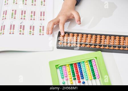 Un écolier fait des mathématiques mentales.Mathématiques mentales.garçon multiracial de 8 ans occupé avec l'arithmétique mentale.Garçon dans les cours de mathématiques.Faire des devoirs, faire des maths à Banque D'Images