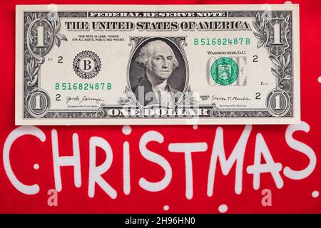 BILLET DE banque US 1 dollar et texte Joyeux Noël sur fond rouge à des fins de conception Banque D'Images