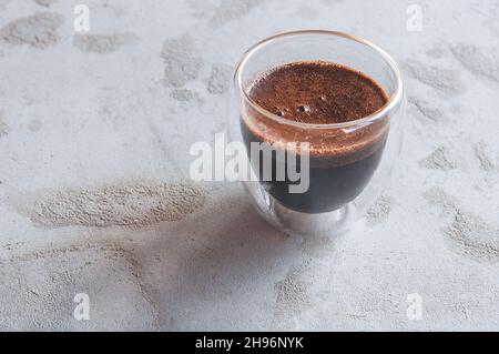 café dans un verre avec des murs doubles sur un fond en béton Banque D'Images