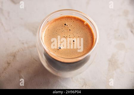 Vue de dessus du café en verre avec des murs doubles sur fond de béton Banque D'Images