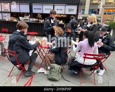 Un groupe d'adolescents déjeunent dans le centre commercial piétonnier le long de Broadway, près de la 34e rue de Manhattan, le Black Friday, le week-end de Thanksgiving, à Manhattan, New York. Banque D'Images