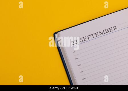 Bloc-notes ou agenda avec la date exacte sur fond jaune.Calendrier pour septembre 22 - heure d'automne.Espace pour le texte. Banque D'Images