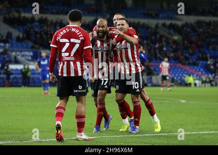 David McGoldrick de Sheffield United (c) célèbre avec ses coéquipiers Billy Sharp de Sheffield Utd (10) et Morgan Gibbs-White de Sheffield Utd après avoir marqué le troisième but de ses équipes.Match de championnat EFL Skybet, Cardiff City et Sheffield United au Cardiff City Stadium de Cardiff, pays de Galles, le samedi 4 décembre 2021. Cette image ne peut être utilisée qu'à des fins éditoriales.Utilisation éditoriale uniquement, licence requise pour une utilisation commerciale.Aucune utilisation dans les Paris, les jeux ou les publications d'un seul club/ligue/joueur. photo par Andrew Orchard/Andrew Orchard sports photographie/Alamy Live news Banque D'Images