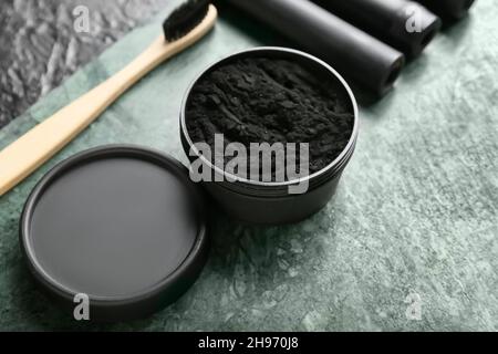 Bocal avec poudre de dent de charbon de bois activée sur fond noir, gros plan Banque D'Images