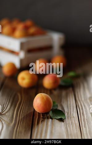 Caisse en bois blanc avec des abricots sur table Banque D'Images