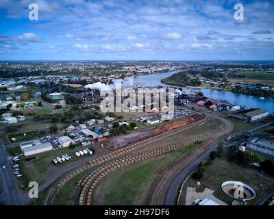 Antenne des trains de canne à sucre se ramenant dans le moulin à sucre de Millaquin et la distillerie de Bundaberg Rum Queensland Australie Banque D'Images