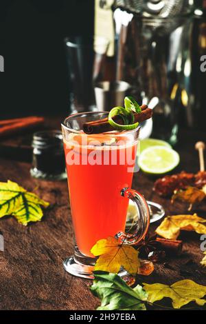 Rhum au beurre chaud, cocktail chaud d'hiver avec jus de pomme, rhum foncé, miel, cannelle en verre sur fond de bois Banque D'Images