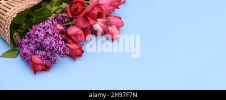 fleurs de tulipes et de lilas dans un panier sur fond bleu. maquette Banque D'Images