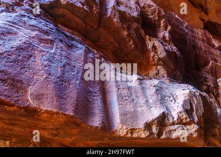 Vue sur les pétroglyphes préhistoriques et les inscriptions dans les rochers falaises, Wadi Rum, parc désertique dans le sud de la Jordanie Banque D'Images