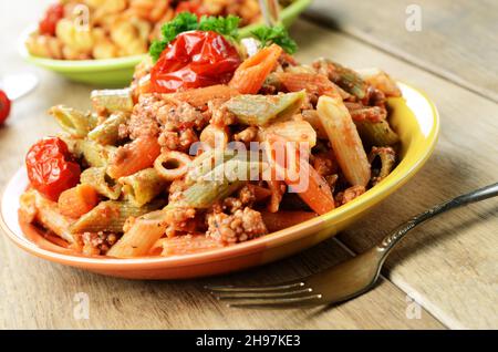 Les pâtes penne avec sauce bolognaise boeuf tomate sur la table de cuisine Banque D'Images