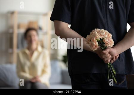 Bouquet de fleurs dans les mains des hommes derrière le dos Banque D'Images