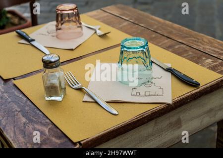 Cadre de table d'un restaurant avec verre et couverts, sur la place Santo Spirito, dans une journée nuageux, dans le quartier Oltrarno, le centre-ville de Florence, en Toscane Banque D'Images