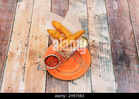 Recette pour les doigts de poulet avec sauces à tremper sur une table en bois avec poivre et origan Banque D'Images