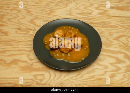 Délicieux pain de poulet à la sauce avec petits pois et carottes sur une table en bois Banque D'Images