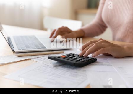 Gros plan une femme qui planifie son budget, à l'aide d'un ordinateur portable et d'une calculatrice Banque D'Images