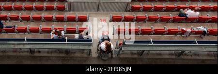 les spectateurs du stade assis dans des sièges rouges regardent le match Banque D'Images