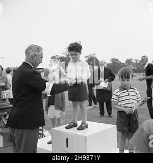 Stade Copthall, Hendon, Barnett, Londres, 25/06/1966.Un jeune garçon sur un podium reçoit un prix, lors de la Journée annuelle des sports de Laing, qui s'est tenue au stade Copthall.En 1966, la Journée annuelle des sports des employés de Laing a eu lieu le 25 juin au stade Copthall à Hendon.C'était la première fois que l'événement s'y tenait, ayant eu lieu auparavant le terrain de sport de Laing à Elstree.Parmi les différents événements, on compte l'athlétisme et une compétition de football, et les concurrents ont voyagé depuis les bureaux et sites régionaux de la société, notamment en Écosse et en Carlisle.Il y avait aussi un Funfair, un groupe de marche, un Banque D'Images