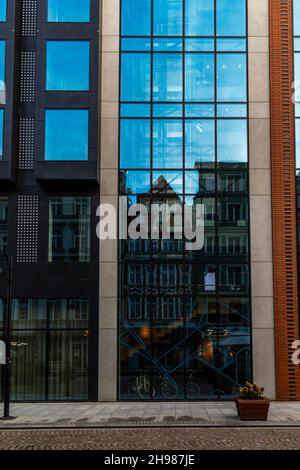 Gdansk, Pologne - octobre 24 2020 : anciens bâtiments en bâtiment qui réfléchit sur le mur vitreux du bâtiment moderne Banque D'Images