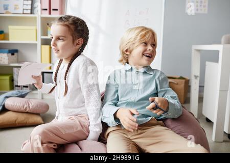 Des enfants heureux jouant les uns avec les autres pendant une pause après la leçon à l'école Banque D'Images