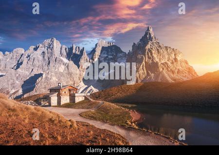 Paysage incroyable avec un reflet du ciel pourpre et des montagnes dans une eau de petit lac dans une destination touristique populaire - Baita Segantini refuge de montagne.Col Rolle, Alpes Dolomites, Italie Banque D'Images