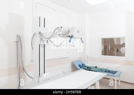 Service de radiologie dans un hôpital moderne.Salle de radiologie avec scanner et lit vide.Le technicien règle un appareil à rayons X.Examen du thorax, du cœur Banque D'Images
