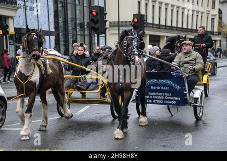 Un groupe de promenades en calèche passant par la gare de Charing Cross.Les militants des droits des animaux criont qu'il s'agit d'une cruauté envers les animaux le 5 décembre 2021, Londres, Royaume-Uni. Banque D'Images