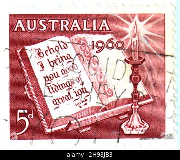 Photo d'un timbre-poste australien rouge de 5d Noël 1960 avec une image des pages de la bible citant Luc 2-10 Banque D'Images