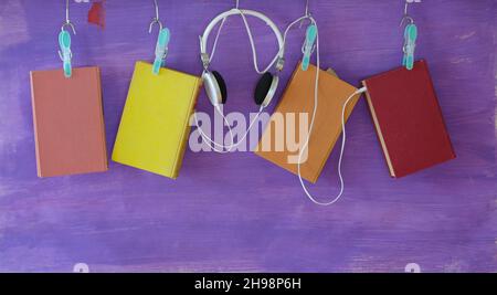 concept de livre audio, avec rangée de livres suspendus et écouteurs modernes grand espace de copie gratuit Banque D'Images