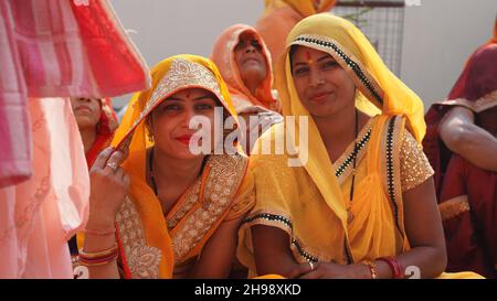 21 novembre 2021 Reengus, Rajasthan, Inde.Deux femmes indiennes en saree jaune regardant l'appareil photo dans une fonction de mariage. Banque D'Images