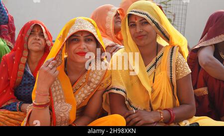 21 novembre 2021 Reengus, Rajasthan, Inde.Des femmes indiennes heureuses en saree jaune regardant l'appareil photo dans un programme de mariage. Banque D'Images