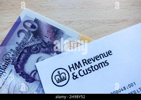 Logo HM Revenue and Customs imprimé sur une lettre avec une note de vingt livres sur la table Banque D'Images
