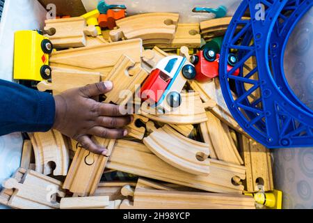 Garçon jouant avec le jouet de train.Garçon indien de 3 ans jouant avec une piste de train en bois et des trains Banque D'Images