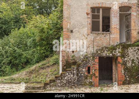 Une ancienne maison européenne qui est abandonnée avec la porte large ouverte et des marches menant vers le haut ainsi qu'une cave Banque D'Images