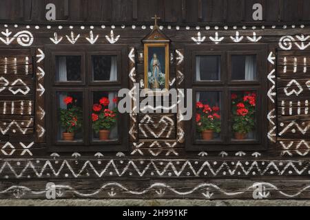 Détail de la maison traditionnelle en rondins décorée de motifs linéaires blancs dans le village de Čičmany dans la région de Žilina en Slovaquie.La maison n° 42 illustrée sur la photo est maintenant utilisée comme musée. Banque D'Images