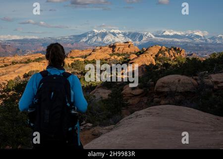 Le randonneur donne sur le Devils Garden Loop et les montagnes de la Sal au loin dans le parc national d'Arches Banque D'Images